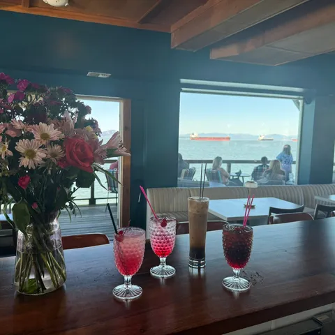 Drinks on the counter inside, with the deck and the river through the windows